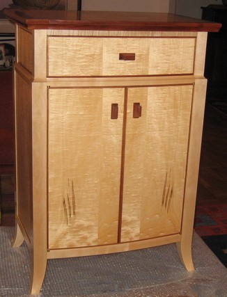 Bowfront cabinet in quilted maple