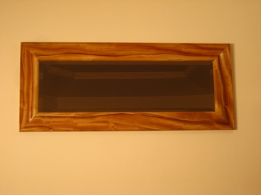 Shaped mirror in camphor wood
